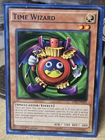 Front of Time Wizard card in sleeve showing title, artwork, stats, edition and set code