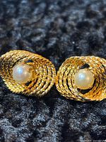 Front view showing gold rope-twist swirl and pearl centers