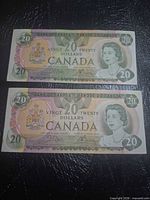 Both $20 Canadian banknotes laid flat, full obverse view