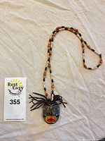 Full view of necklace showing pendant, beads and measuring card