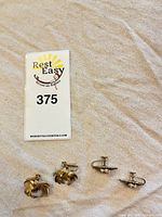 Four earrings: Trifari spiral pair and seashell pair with lot tag