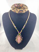 Necklace displayed on bust with earrings above, showing overall design and stone arrangement