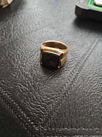 Frontal view of gold-plated signet ring showing black onyx stone