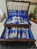 Open two-drawer chest showing wrapped flatware