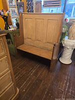 Front view of pine settle bench showing high paneled back and seat