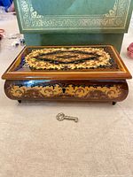 Closed wood inlay music box with key in front