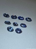 All nine oval-cut Tanzanite stones grouped on neutral background