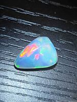 Front view of polished pear opal showing multicolor flashes