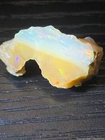 Full view of opal rough showing white seam and brown base with colour flashes