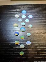 All opals laid out in vertical row on dark background