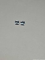 Two cushion-cut pale blue gemstones on neutral background