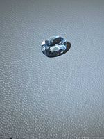 Top view of oval aquamarine on light surface