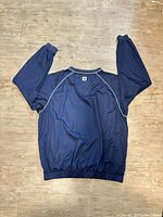 Back of windbreaker displaying piping and FootJoy logo at neck