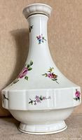 Front view of white porcelain decanter with floral decoration