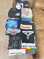 Stack of folded graphic T-shirts showing various prints