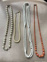 Group view of all four necklaces laid out side by side