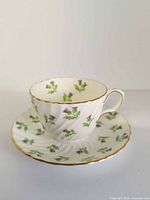Teacup on saucer showing pattern and gold trim