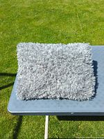 Top view of grey fluffy triangular cushion on table