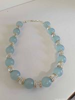 Full view of entire Joan Rivers pale blue bead rhinestone necklace laid flat