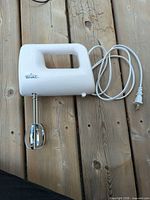 Side view of Rival hand mixer with cord and one beater