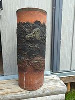 Full view of terracotta cylinder showing relief dragon and rim pattern