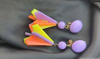 Both earrings front view on fabric background