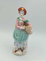 Full view of porcelain lady figurine showing pose, colours and base