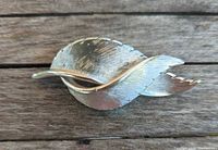 Front view of Coro silver-tone leaf brooch showing overlapping leaves and texture
