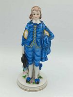 Full view of figurine showing posture, clothing, base
