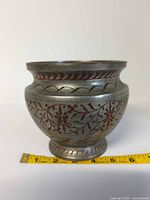 Full view of metal bowl with tape measure for scale