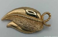Front view of goldtone Monet leaf brooch