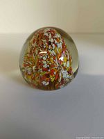 Front view of glass paperweight showing internal colourful pattern