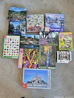 All 12 puzzle boxes laid out showing cover images and 1000-piece labels