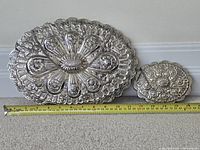 Front view of both silver-plated mirrors with measuring tape for scale