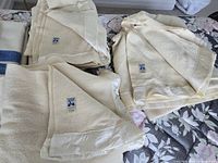Three folded cream wool blankets with Kenwood labels visible