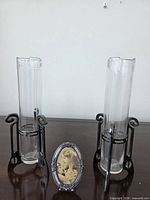 Both glass bud vases in stands and oval photo frame displayed together