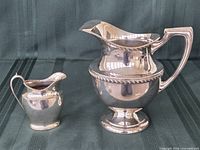 Pitcher and creamer front view showing size difference and finish