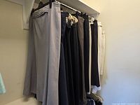 Group of skirts hanging on rail showing range of colours and fabrics