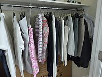 Row of assorted golf tops, skorts and pants on hangers