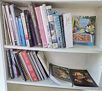 Two shelves filled with hardcover, paperback and spiral-bound cookbooks