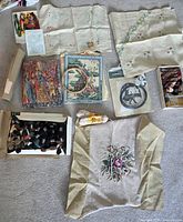 Overview of all items laid out: yarn box, printed canvases, hoop, linens, accessories