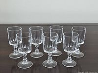 Set of seven identical cordial glasses displayed upright