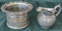 Overall view of silver plate wine coaster and Wilcox creamer