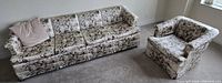 Floral sofa and matching armchair on carpeted floor