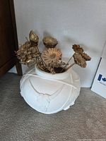Front view of ceramic vase with gold flowers inside