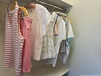 Group of tennis tops and skirts on hangers