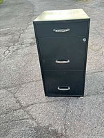Front view of black 3-drawer metal filing cabinet showing handles and lock