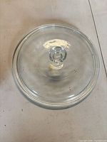 Top view of round clear glass lid with knob