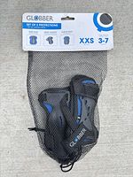 Front view of Globber protective gear set in net packaging showing pads