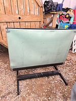 Front view of drafting table showing green top and black metal base
